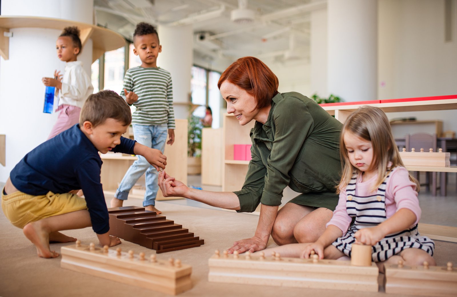 Teacher guiding children through Montessori work